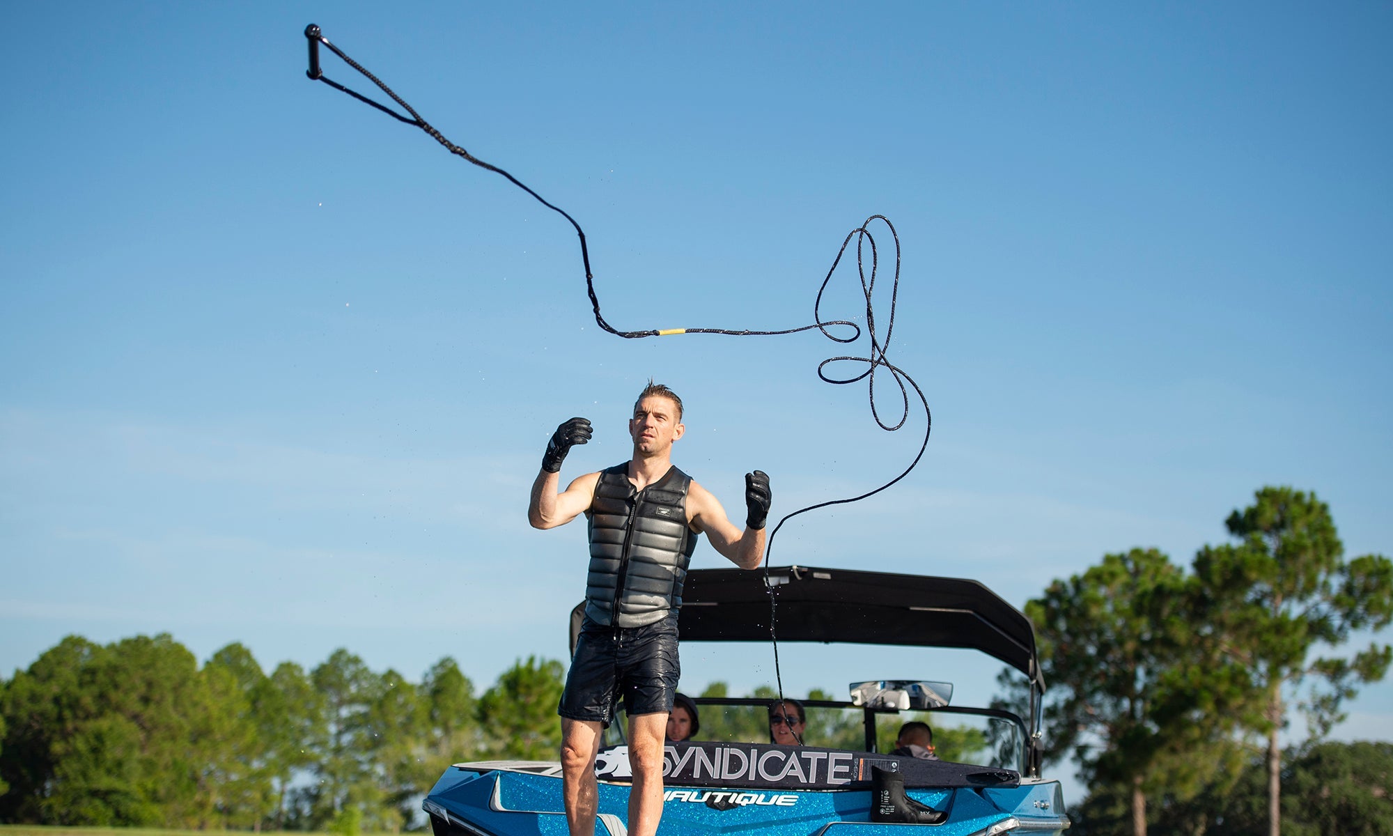 Water Skier throwing his tow rope and handle into the water off a boat with his Syndicate Water Ski ready to ride.
