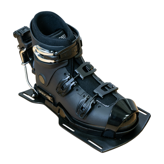 Angled view of the Syndicate Hardshell Demo Program boot with a black shell, metal buckles, and rear release.