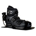 Angled front view of the Syndicate Hardshell boot, showing black construction, adjustable straps, and a metal heel release.