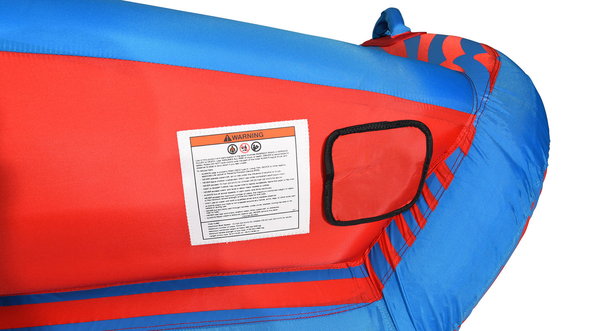 Close-up of the 4G Tube's red side panel with the tow-point cover and warning label.