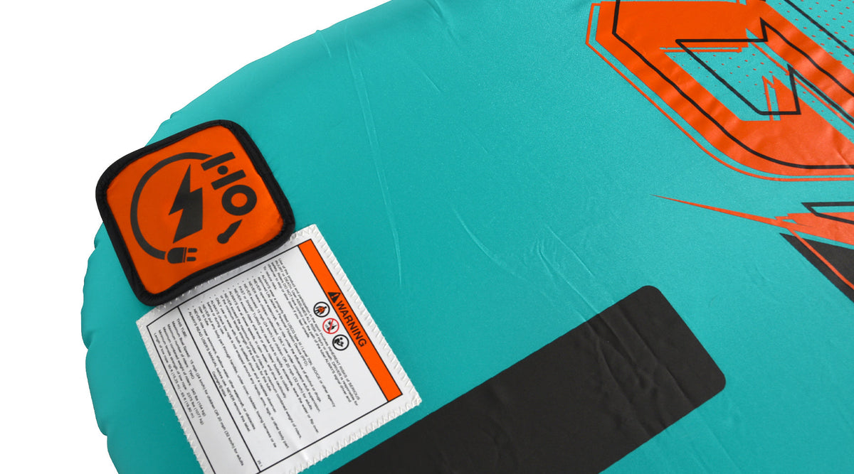 Close-up of an orange HO logo patch and warning label on the teal fabric.