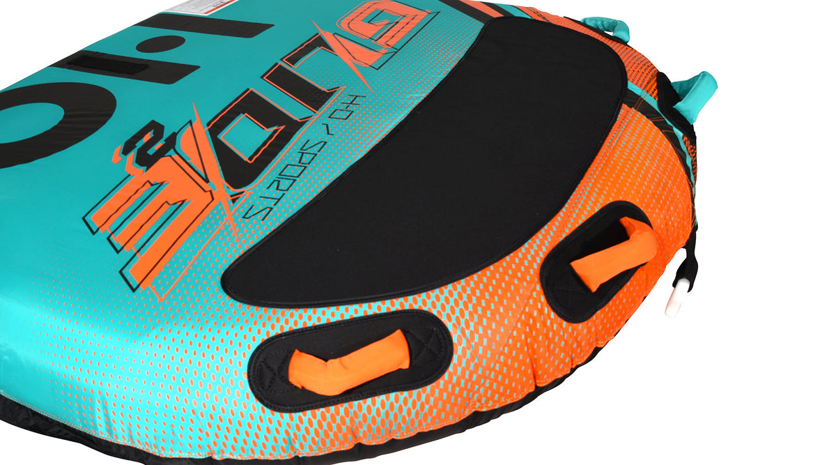 Close-up of the black center pad and orange grab handles on the teal and orange dotted deck.