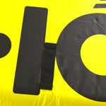 Close-up view of Glide 3 Tube large black logo on bright yellow surface.