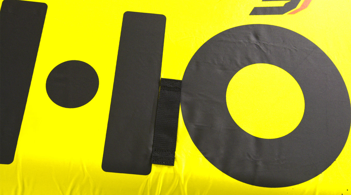 Close-up of the black HO graphic and a grab strap on the yellow fabric.