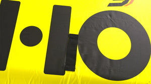 Close-up of the black HO graphic and a grab strap on the yellow fabric.