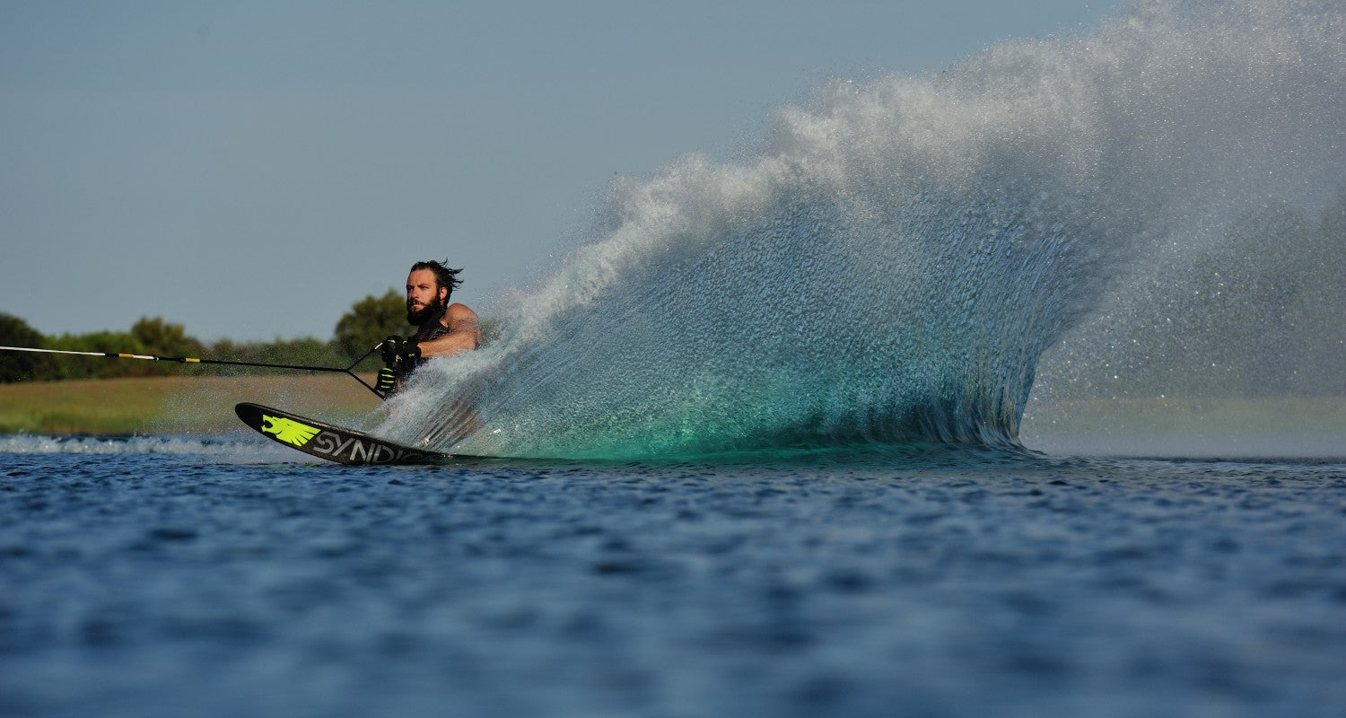 Matteo Luzzeri executing a deep turn on his Syndicate ski, generating a large water spray.