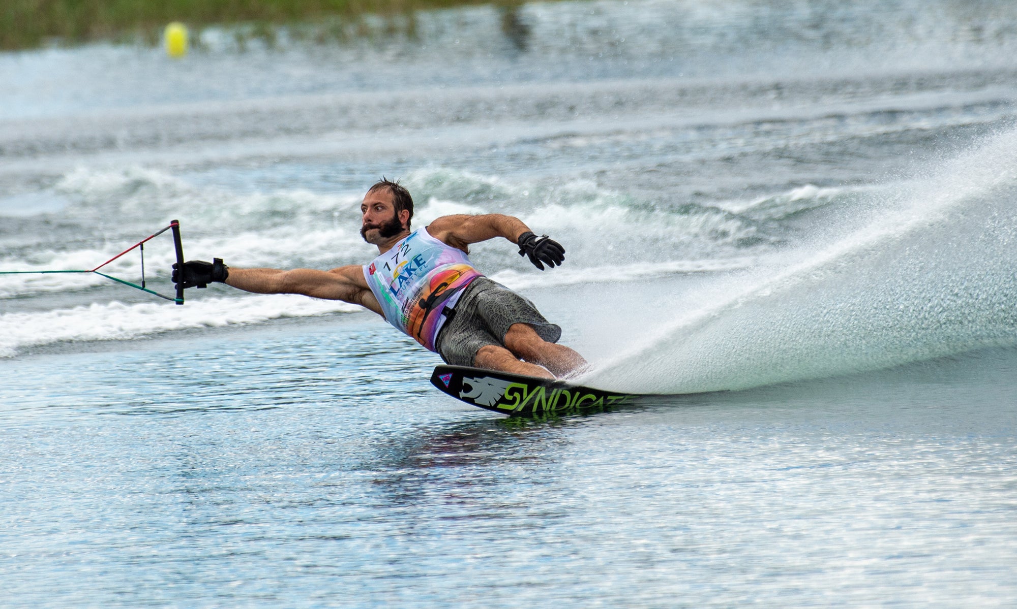 Matteo Luzzeri competing in a waterski event, leaning into a turn with the tow rope in his hand.