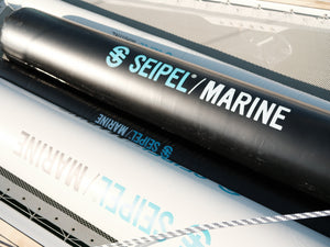 Close-up of black inflatable dock fenders with Seipel Marine logo resting on a boat deck.