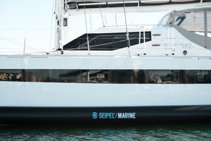 Side view of a boat hull with Seipel Marine inflatable dock fender mounted along the waterline.
