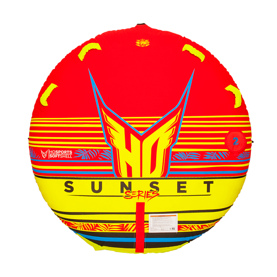 Top view of the HO Sports Sunset 2 towable tube featuring a vibrant red, yellow, and black softshell design with bold HO logo, tropical accents, and "Sunset Series" text printed across the center.