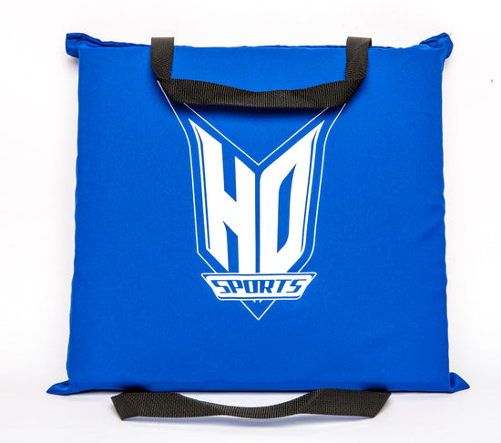 Top view of the Seat Cushion PFD, blue with a large white HO Sports logo and black grab straps on two sides.