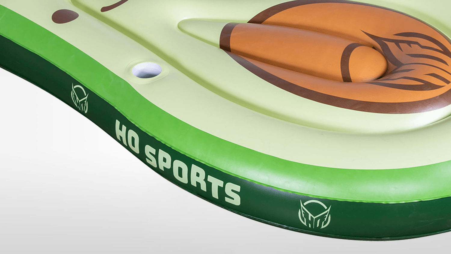 Angled view of Avocado Lounger's green avocado surface with brown pit, cup holder, and HO Sports logo.