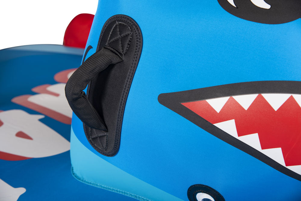 Close-up of Shark tube's blue shark face graphic with black padded handle and red jagged teeth illustration.