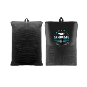 Front and back of the Syndicate Cinch Changing Mat in its compact form, featuring a black mesh storage bag with a white logo.