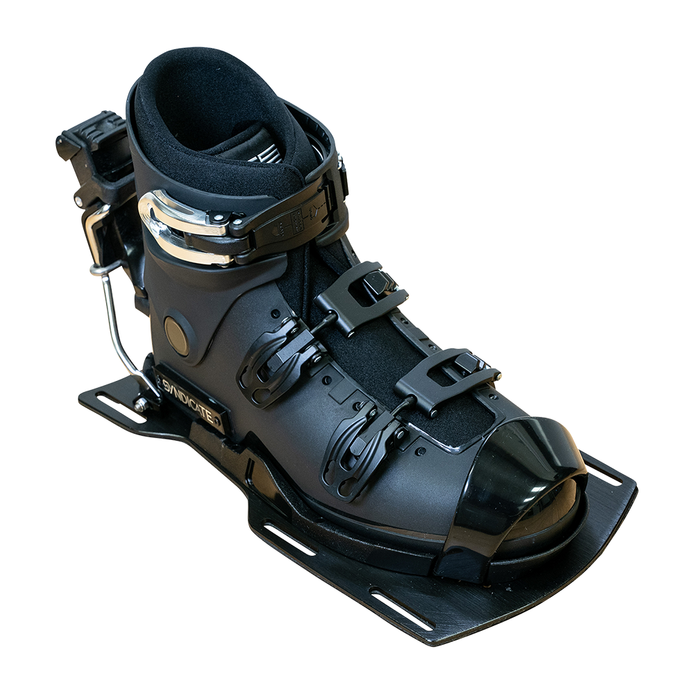 Angled view of the Syndicate Hardshell Demo Program boot with a black shell, metal buckles, and rear release.
